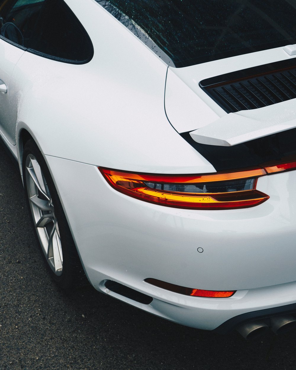 Rear quarter detail of a white Porsche 911